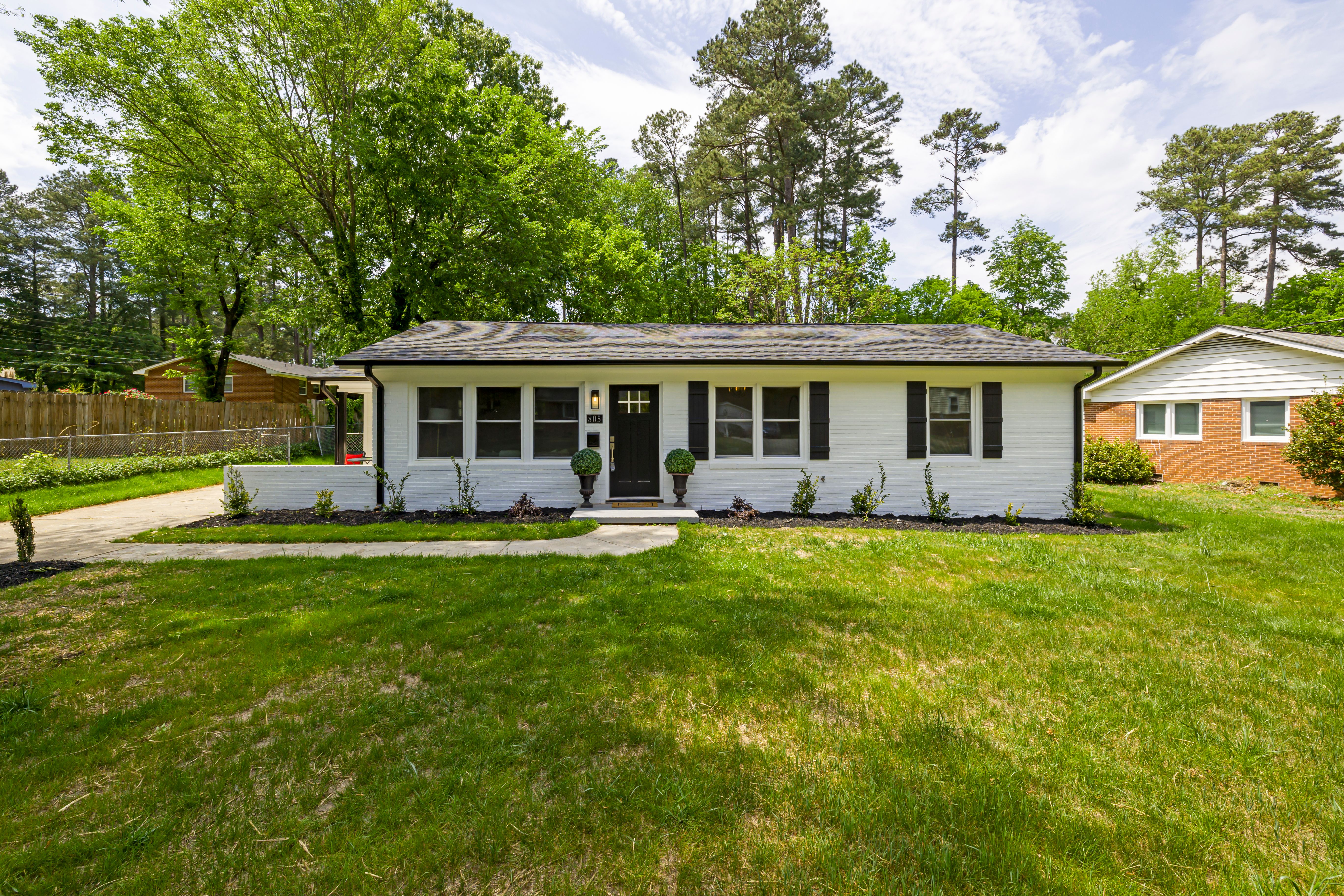 A welcoming home surrounded by lawn and mature trees